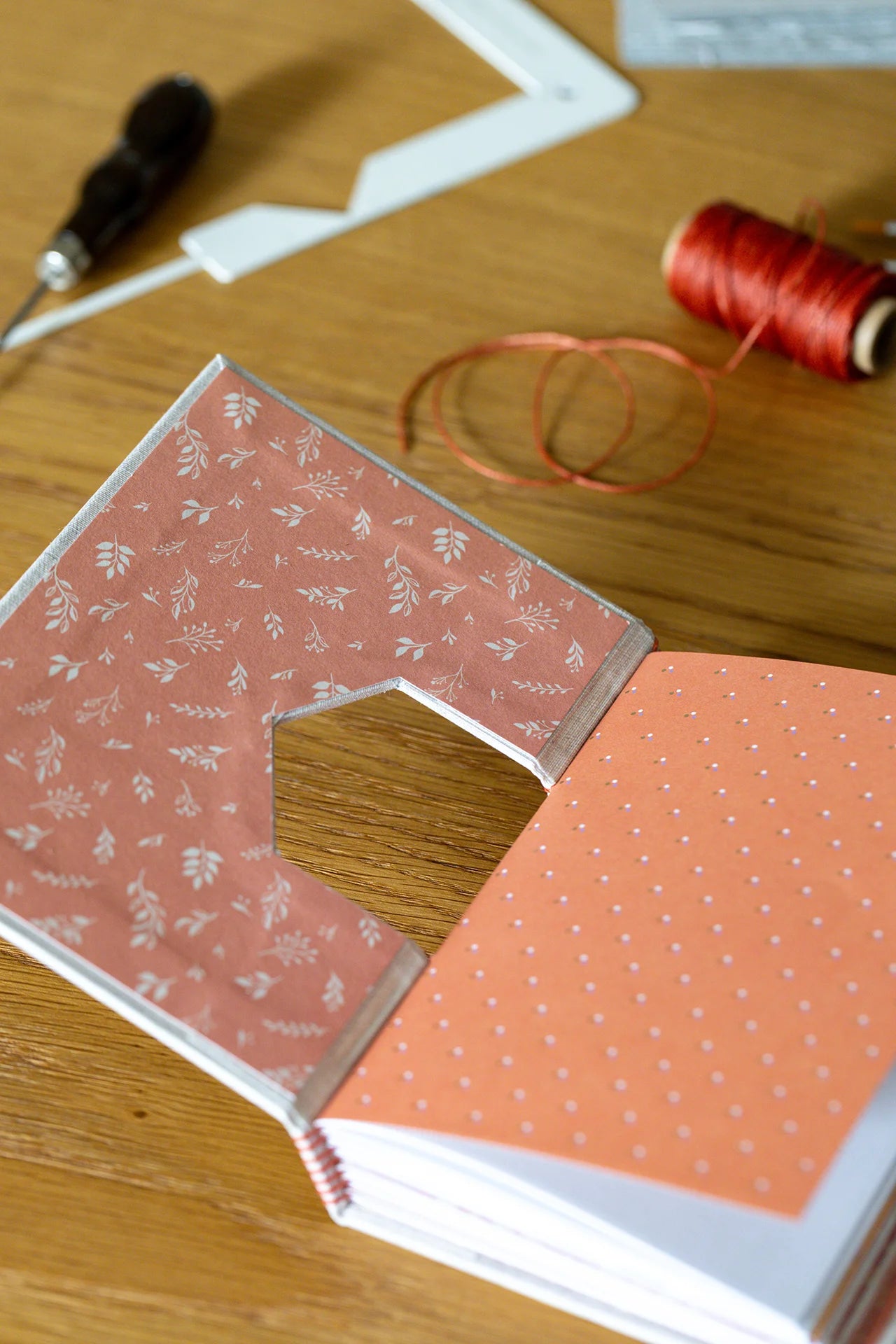 Dettaglio dell'interno della copertina con intaglio geometrico, carte decorate con pattern nobilitate in lamina oro.