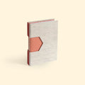 Taccuino A6 rilegato a mano con tecnica Buttonhole, foro geometrico in copertina che lascia vedere le carte decorate dei fascicoli interni, filo corten decorativo, ideale per regali unici sostenibili che lasciano a bocca aperta.